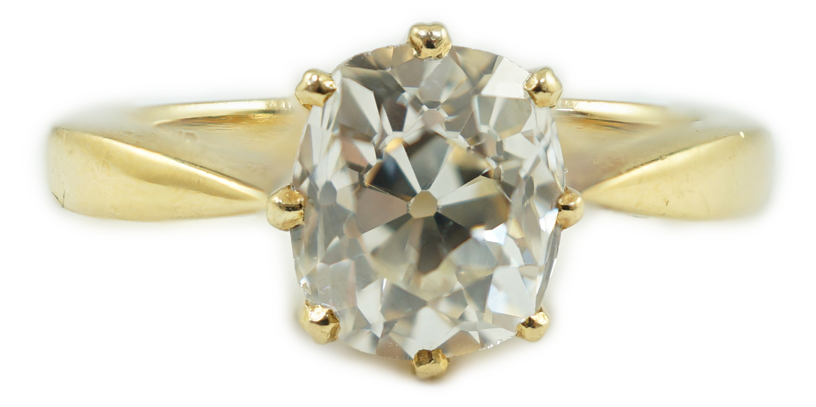 An 18k gold and oval cushion cut solitaire diamond ring